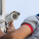 Security System AMC Services technician performing CCTV camera maintenance and inspection.