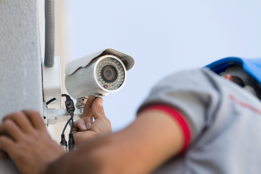 Security System AMC Services technician performing CCTV camera maintenance and inspection.