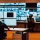 Security operators actively monitoring live video feeds on a video wall inside a corporate SOC